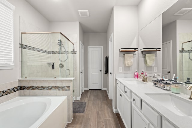 bathroom featuring hardwood / wood-style floors, shower with separate bathtub, and vanity