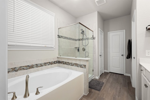 bathroom featuring shower with separate bathtub, vanity, and hardwood / wood-style floors