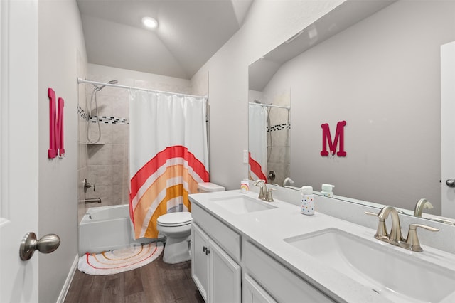 full bathroom with hardwood / wood-style floors, vanity, shower / bath combo, toilet, and vaulted ceiling