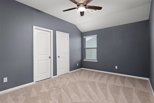 unfurnished bedroom featuring carpet, vaulted ceiling, and ceiling fan