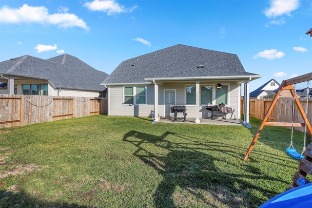 back of house with a playground, a lawn, ceiling fan, and a patio area