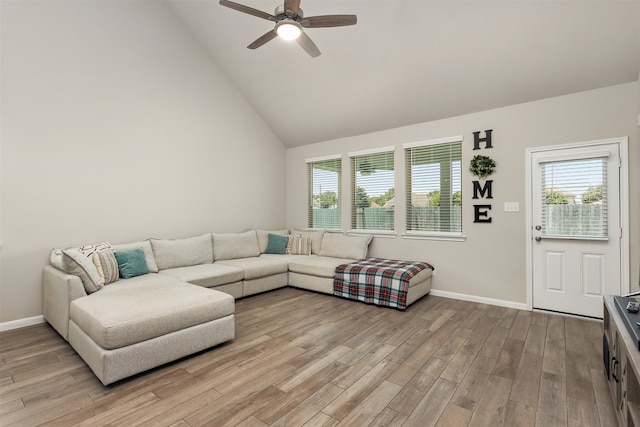 living room with ceiling fan, plenty of natural light, light hardwood / wood-style flooring, and high vaulted ceiling