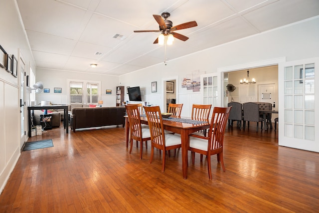 dining area featuring french doors, wood-type flooring, and ceiling fan with notable chandelier