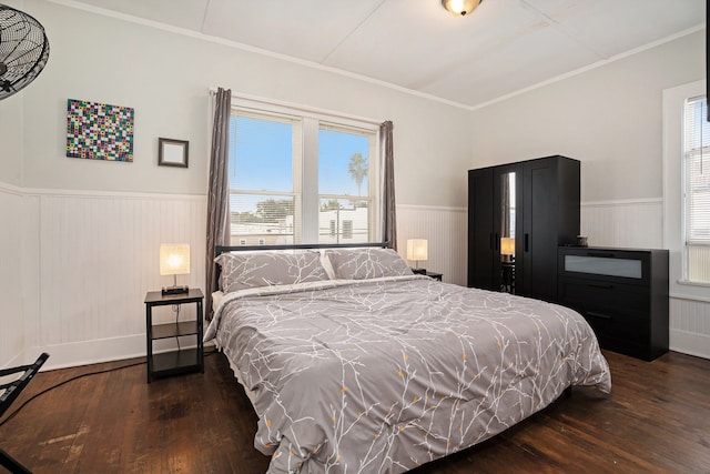 bedroom with dark hardwood / wood-style floors and ornamental molding