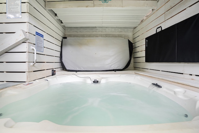 bathroom with wooden walls and beam ceiling