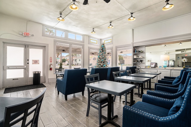 dining area with light hardwood / wood-style floors, a textured ceiling, and a healthy amount of sunlight