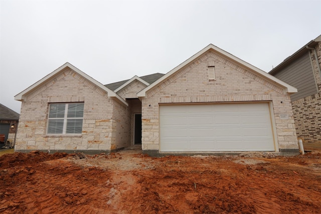 view of front of house with stone siding, brick siding, and an attached garage