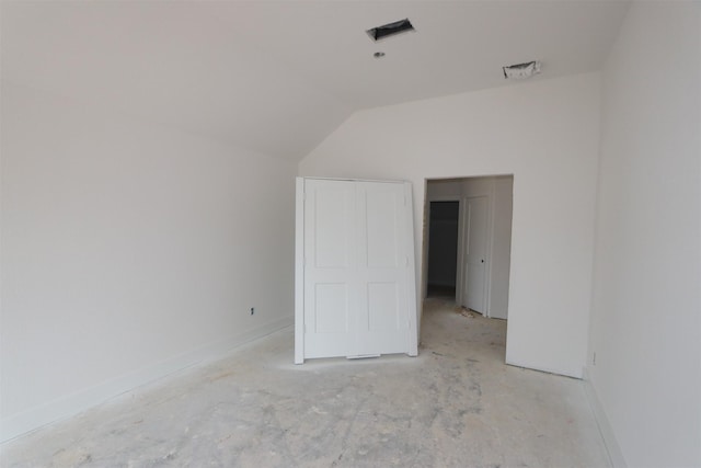 unfurnished bedroom with lofted ceiling, visible vents, and baseboards