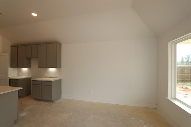 kitchen featuring plenty of natural light, gray cabinetry, and vaulted ceiling