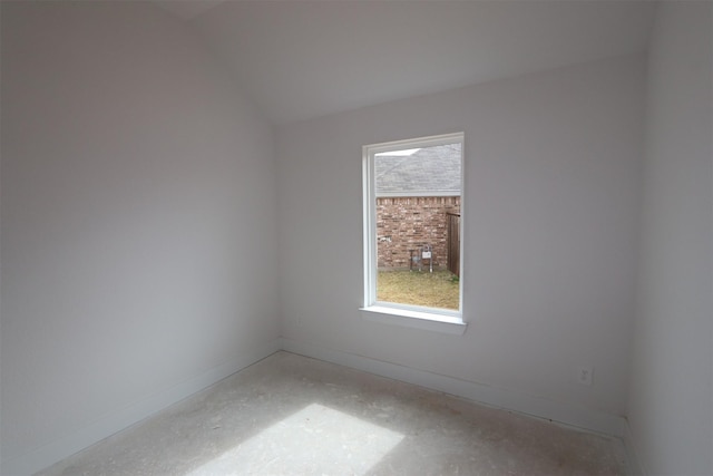 empty room with a wealth of natural light, baseboards, and lofted ceiling