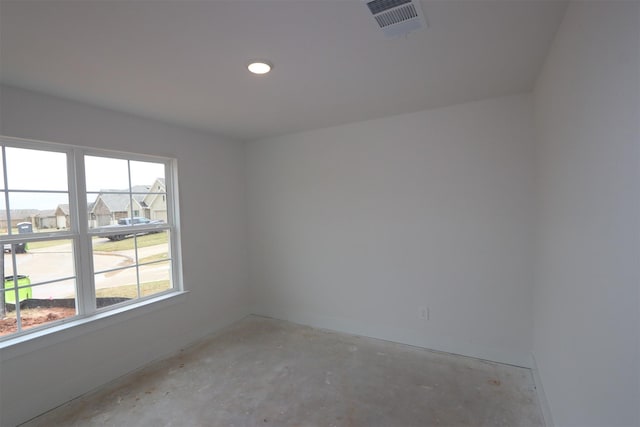 spare room with visible vents, baseboards, and concrete flooring