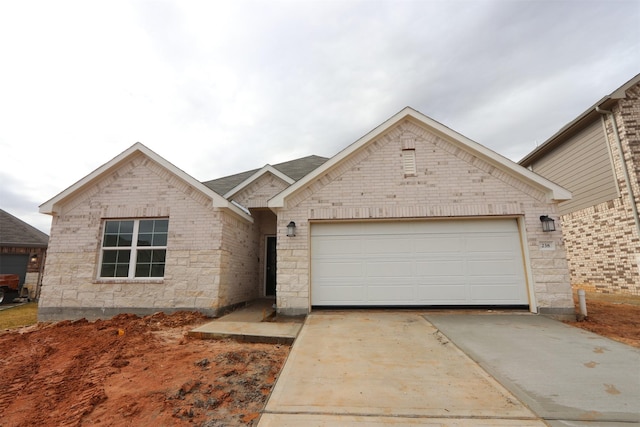 view of front of home with a garage, brick siding, and driveway