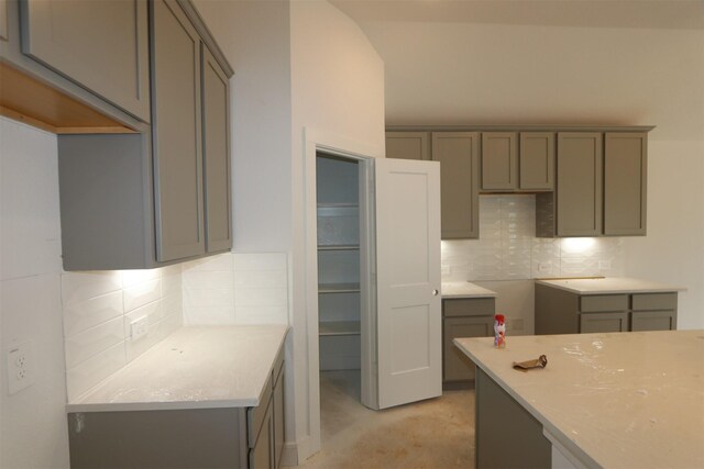 kitchen with light countertops, gray cabinets, and backsplash