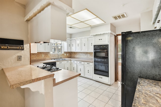 kitchen featuring white cabinetry, black appliances, kitchen peninsula, and tasteful backsplash