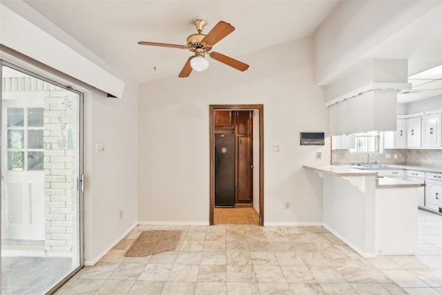 kitchen featuring white cabinetry, kitchen peninsula, fridge, lofted ceiling, and ceiling fan