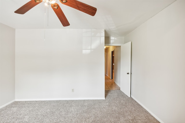 empty room featuring ceiling fan and light carpet