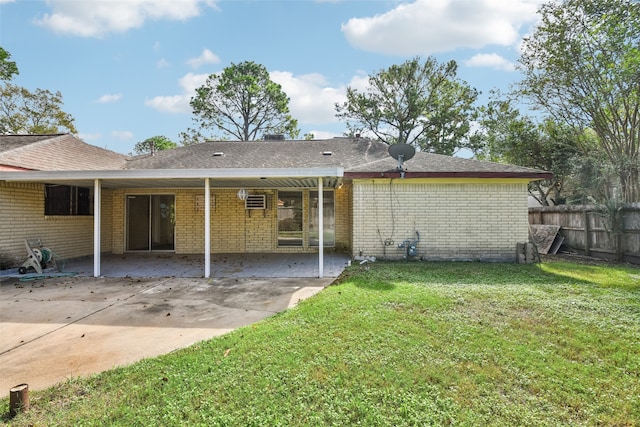 rear view of property featuring a patio area and a yard