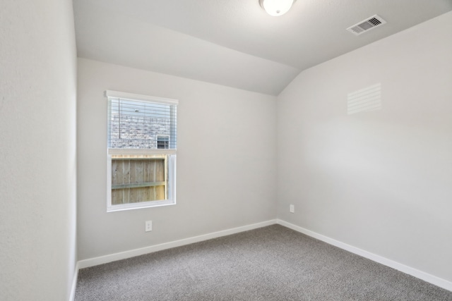 spare room featuring lofted ceiling and carpet