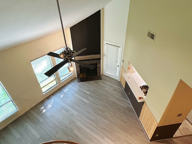 unfurnished living room featuring a high ceiling, ceiling fan, and hardwood / wood-style flooring