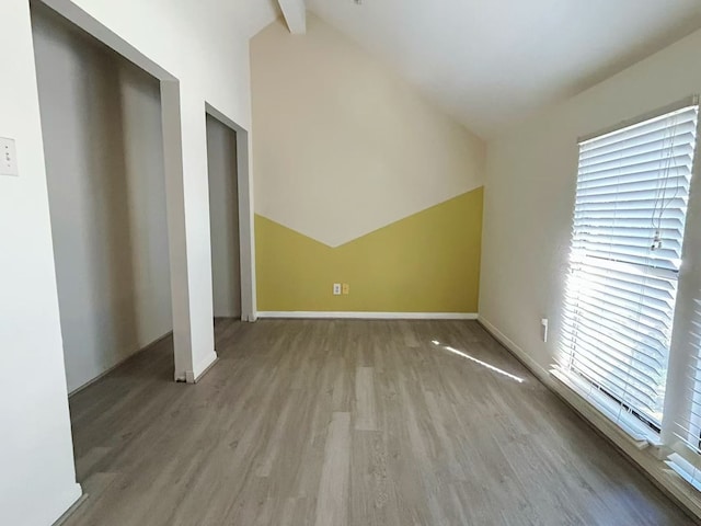 bonus room featuring lofted ceiling with beams and light hardwood / wood-style floors