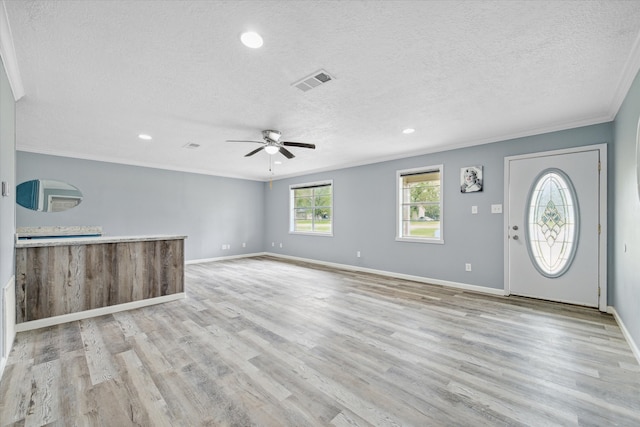 unfurnished living room with a textured ceiling, light hardwood / wood-style flooring, ceiling fan, and ornamental molding