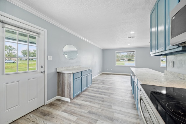 kitchen featuring blue cabinets, ornamental molding, a textured ceiling, and light wood-type flooring