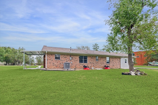 rear view of property with a yard and central air condition unit