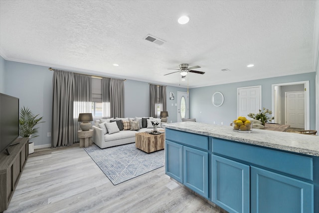 living room with ceiling fan, light hardwood / wood-style floors, crown molding, and a textured ceiling