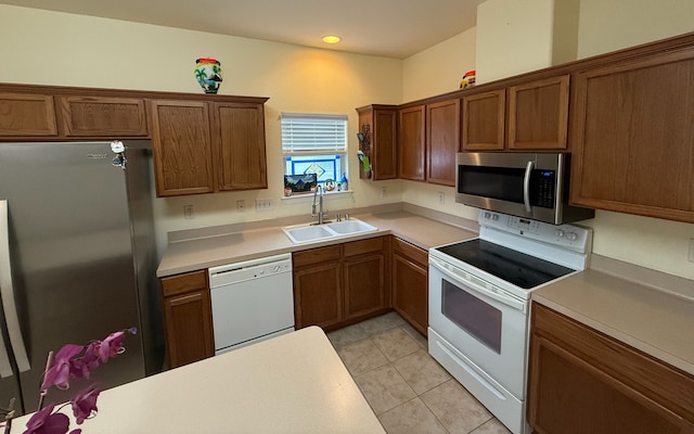 kitchen with appliances with stainless steel finishes, sink, and light tile patterned floors