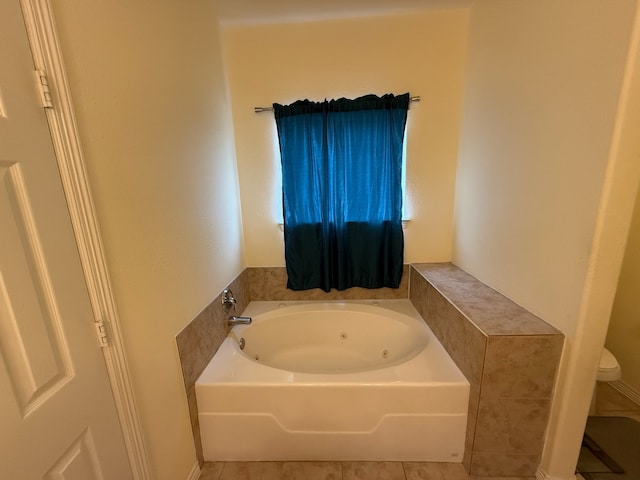 bathroom featuring tile patterned flooring, toilet, and a bathing tub