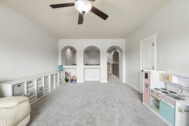 game room with ceiling fan, light colored carpet, and sink