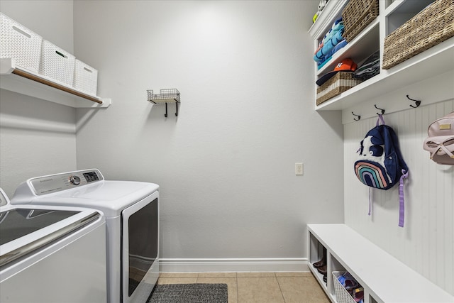 laundry area with separate washer and dryer and light tile patterned flooring