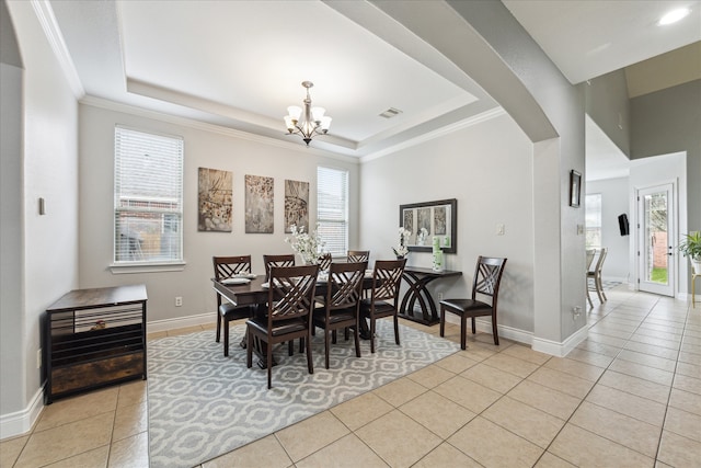 dining area featuring light tile patterned floors, a tray ceiling, and crown molding