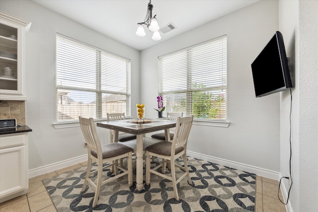 tiled dining area featuring a notable chandelier