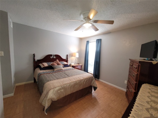 bedroom featuring ceiling fan, a textured ceiling, and light parquet flooring