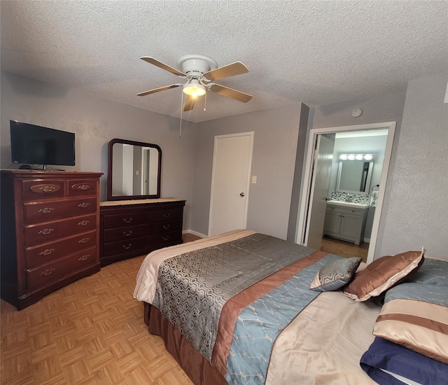 bedroom with ensuite bathroom, ceiling fan, a textured ceiling, and light parquet floors