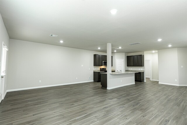 unfurnished living room featuring sink and dark hardwood / wood-style floors