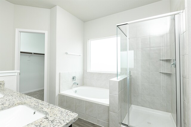 bathroom featuring independent shower and bath, wood-type flooring, and vanity