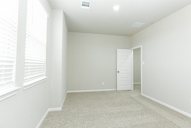 spare room featuring light carpet
