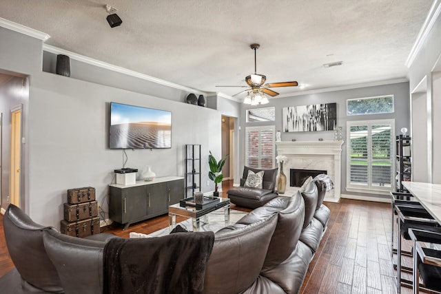 living room featuring a textured ceiling, crown molding, a premium fireplace, and dark hardwood / wood-style floors