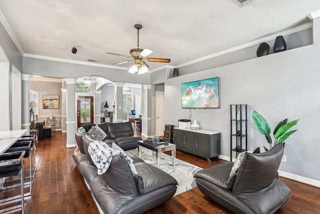 living room featuring ceiling fan, dark hardwood / wood-style flooring, ornate columns, and crown molding