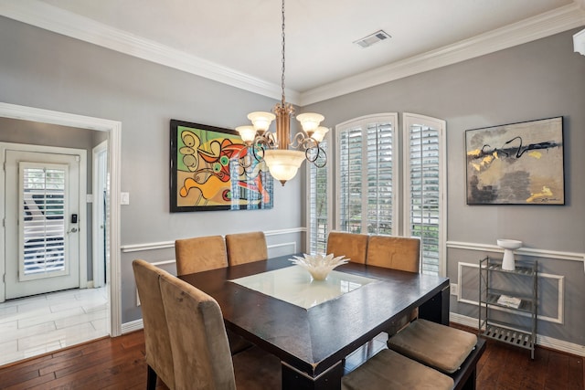 dining area featuring ornamental molding, dark wood-type flooring, and a notable chandelier