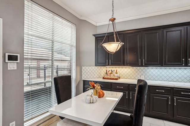 dining room with light tile patterned floors and crown molding