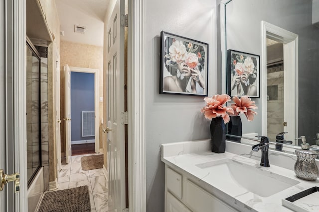 bathroom with combined bath / shower with glass door and vanity