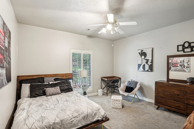 bedroom featuring a textured ceiling, ceiling fan, and light carpet