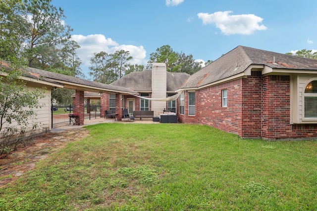 rear view of property featuring a yard, an outdoor living space, and a patio area