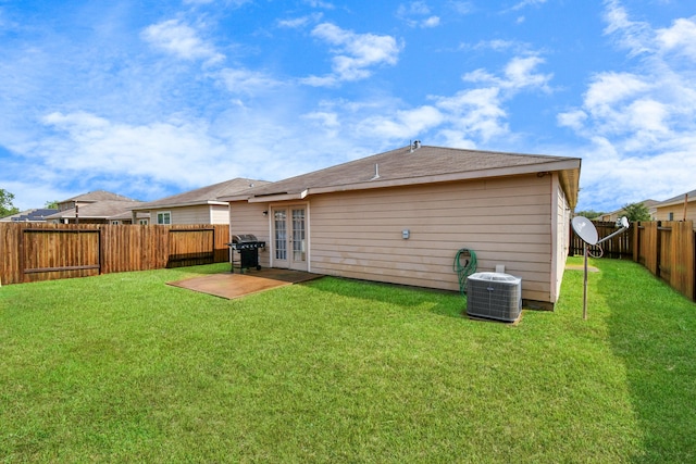 back of house featuring a lawn, cooling unit, and french doors