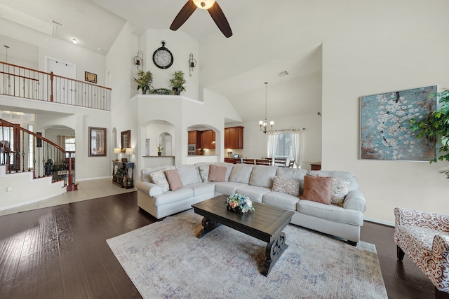 living room featuring high vaulted ceiling, ceiling fan with notable chandelier, and light wood-type flooring