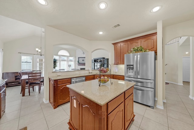 kitchen with a center island, stainless steel appliances, tasteful backsplash, vaulted ceiling, and light tile patterned floors