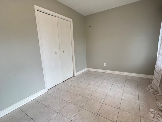 unfurnished bedroom featuring a closet and light tile patterned floors